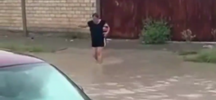Mujer cruza las inundaciones para comprar un refresco